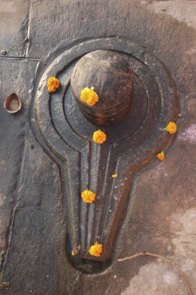 INDIA, Uttar Pradesh, Varanasi, Shiva lingam decorated with marigolds near Chauki Ghat