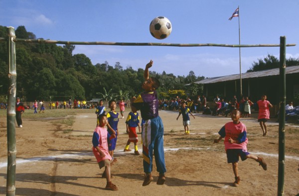 THAILAND, Chiang Rai Province, Doi Lan, Lisu boys playing soccer in a village school yard