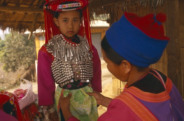 THAILAND, Chiang Rai Province, Huai Khrai, Young Lisu girl dressed in her New Year finery while her