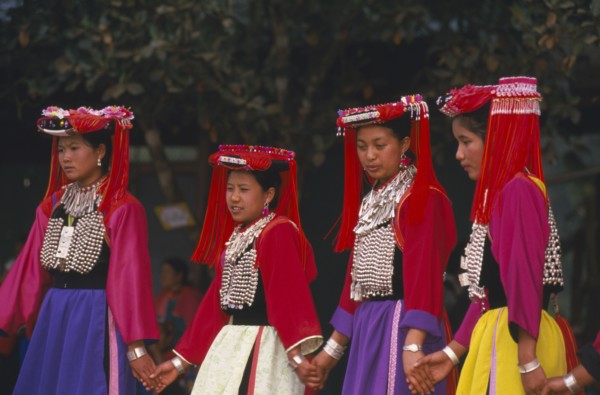 THAILAND, Chiang Rai Province, Huai Khrai, Young Lisu women dancing in their New Year finery