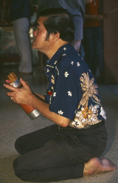 THAILAND, Chiang Mai, Chinese New Year. Worshipper at a Chinese temple during the New Year