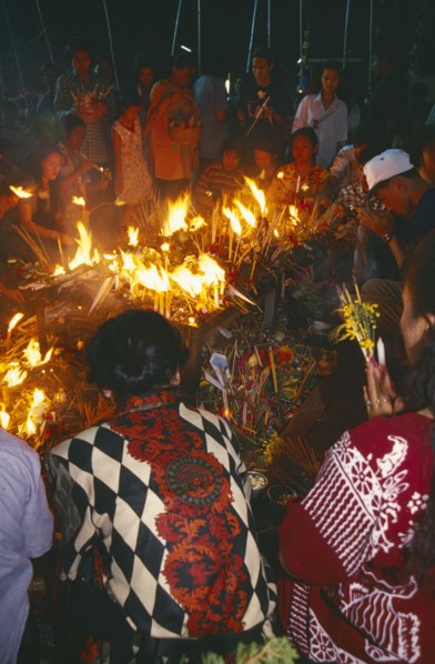 THAILAND, Chiang Mai, Wat Jedi Luang, Inthakhin Ceremony. People offering candles and joss sticks