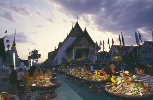 THAILAND, Chiang Mai, Wat Jedi Luang, Inthakhin Ceremony. People offering flowers and joss sticks