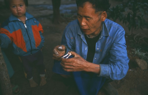 THAILAND, Chiang Rai Province, Doi Lan, Lisu elder reading a pair of chicken wings for oracular