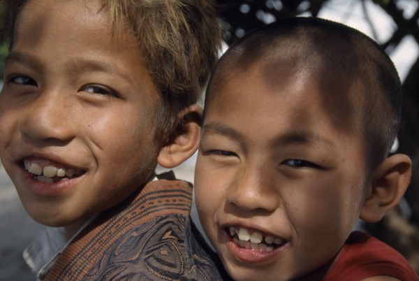 MYANMAR, Amarapura, Portrait of smiling novice monk and temple boy on Lake Taungthaman near