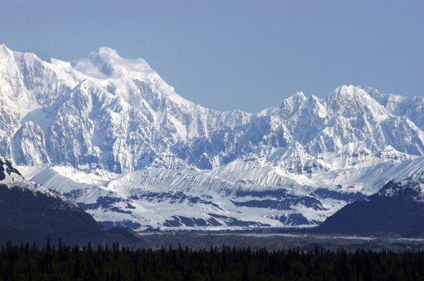USA, Alaska, Snow covered mountain range seen over green treetops