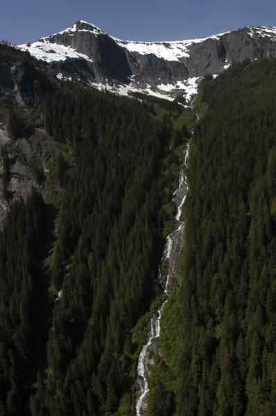 USA, Alaska, Misty Fjords Nat. Monument, Snow capped mountain tops with waterfall running down