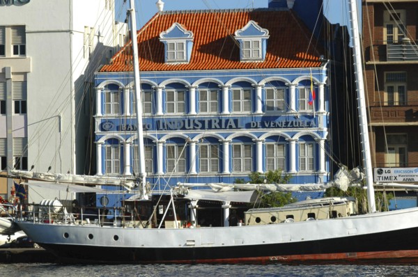 WEST INDIES, Dutch Antilles, Curacao, Willemstad harbour front bank with boat moored in front