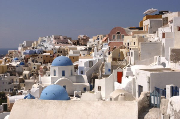 GREECE, Cyclades, Santorini, View over the towns predominantly white architecture with blue domed