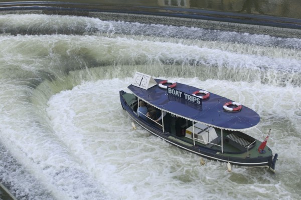 ENGLAND, Bath, A pleasure boat in the weir beneath Pulteney Bridge.