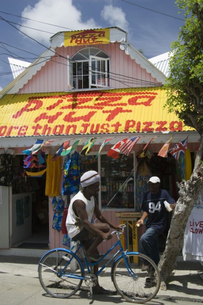 WEST INDIES, St Vincent & The Grenadines, Union Island, Men talking outside pizza restaurant and
