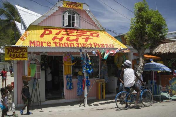 WEST INDIES, St Vincent & The Grenadines, Union Island, Men talking outside pizza restaurant and
