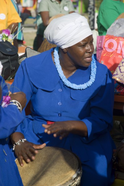 WEST INDIES, St Vincent & The Grenadines, Union Island, Woman playing a drum amongst the Baptist