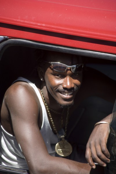 WEST INDIES, St Vincent & The Grenadines, Union Island, Young man in minibus wearing large golden