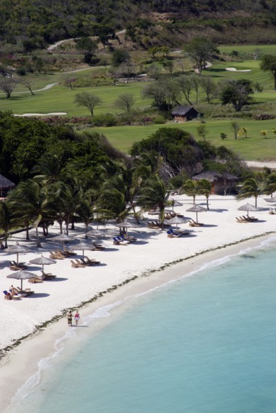 WEST INDIES, St Vincent & The Grenadines, Canouan, Two women walking along Jambu Beach at Raffles