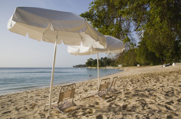 WEST INDIES, Barbados, St Peter, Sunshade umbrellas on Gibbes Bay beach in late afternoon