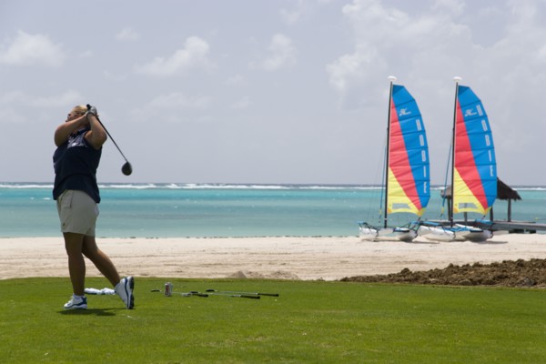 WEST INDIES, St Vincent & The Grenadines, Canouan, Lady golfer teeing off on the Raffles hotel