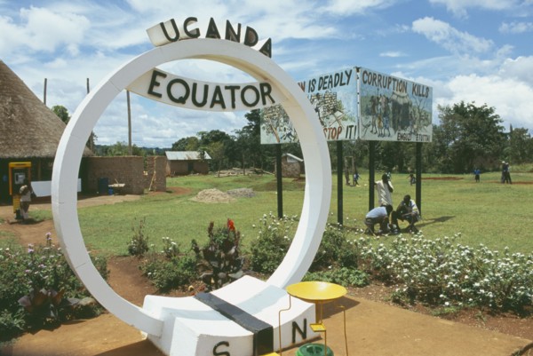 UGANDA, Equator, North and South sign. Corruption kills sign in the background.