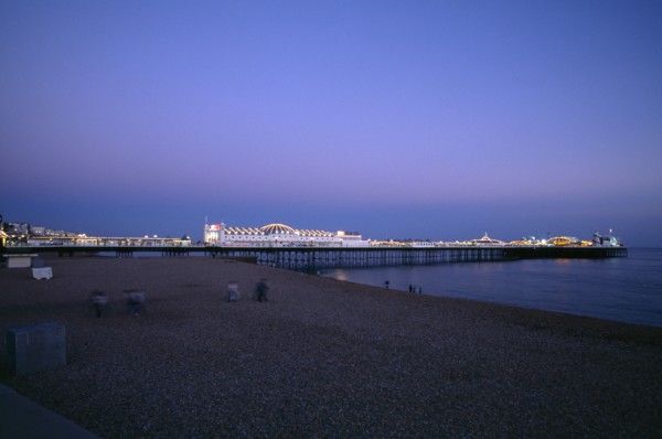 ENGLAND, East Sussex, Brighton, Brighton Pier illuminated in evening light.