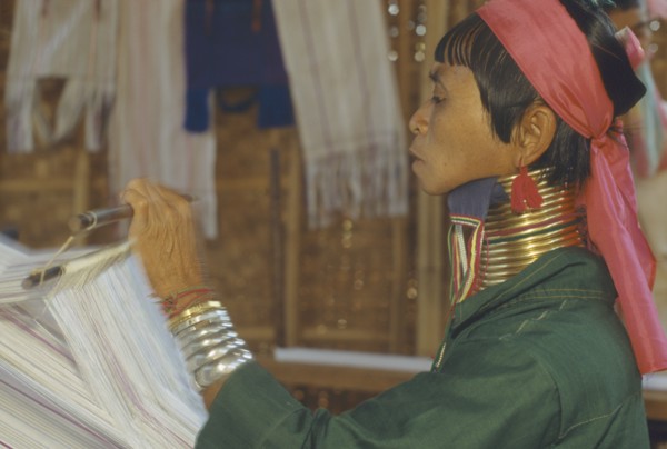 THAILAND, Chiang Rai, "Woman weaving at Karennie village. Paduang, long neck, metal rings."