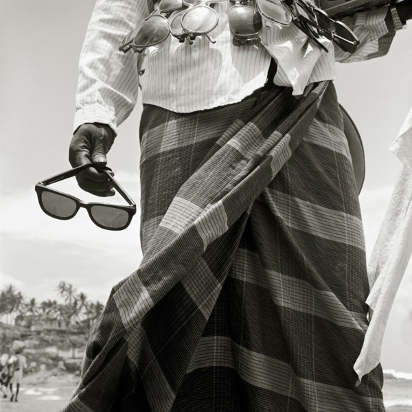 INDIA, Kerala, Kovalam Beach, A sunglass-seller displays his wares on a tourist beach in southern