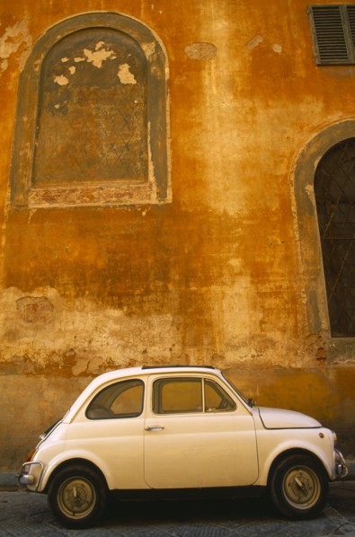 ITALY, Tuscany, Florence, White Fiat 50 parked outside old building with faded ochre coloured