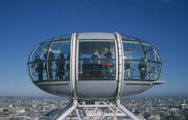 ENGLAND, London, British Airways London Eye capsule and the London skyline with tourist waving to