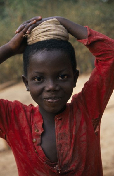 GHANA, Children, Portrait of young girl with coiled cloth on her head for carrying water pot.