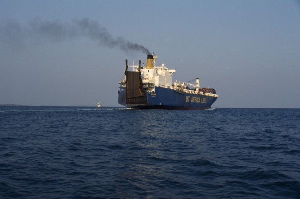 GHANA, Transport, Container ship leaving Tema port emitting stream of thick black smoke from
