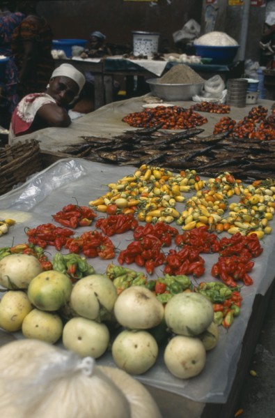 IVORY COAST, Abidjan, Display of vegetables and fish for sale in the covered market with female