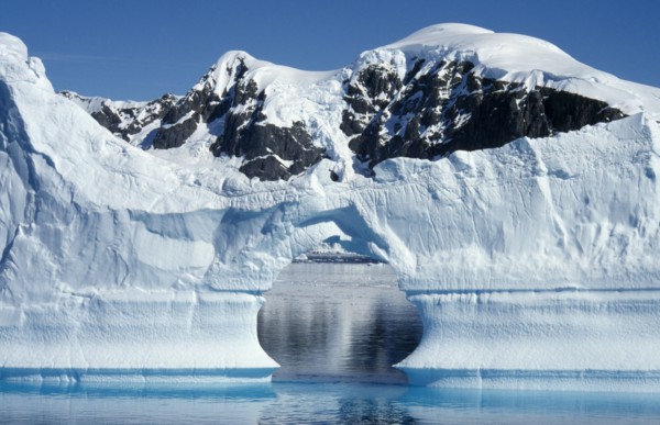 ANTARCTICA, Peninsula Region, Ice Cliffs with an arch shaped gap in the middle and snow covered