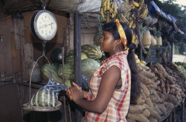 DOMINICAN REPUBLIC, Produce, Young woman weighing bag of produce at roadside fruit and vegetable