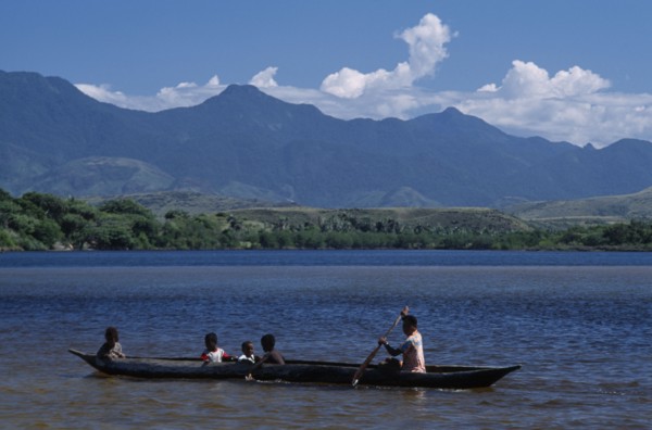 MADAGASCAR, Fort Dauphin, Lokaro, Mother ferrying her children across the bay in a Pirogue with