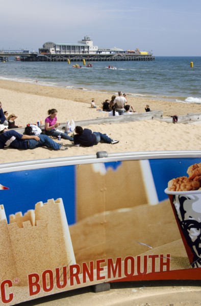 ENGLAND, Dorset, Bournemouth, Tourists playing in the sand and watching speedboat races off the