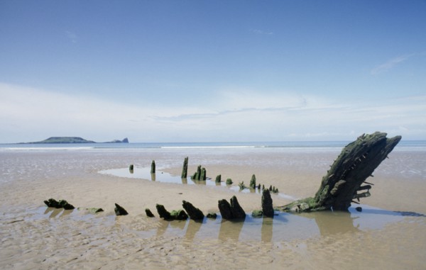 WALES, Gower Peninsula, Rhossili Bay , Helvetia 1890’s shipwreak. Oak carcass on sandy beach at low