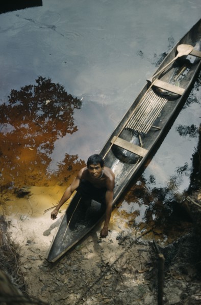 COLOMBIA, Vaupes Region, Tukano Tribe, Man beaches his canoe at a river port; note fishing rod and
