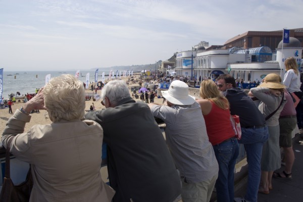 ENGLAND, Dorset, Bournemouth, Tourists watching speedboat races off the West Beach with the