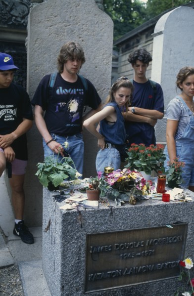 FRANCE, Ile de France, Paris, Pere Lachaise Cemetery. Visitors surrounding Jim Morrison’s Grave