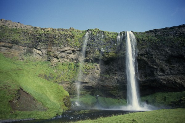 ICELAND, South Coast, Waterfall plummeting over cliff by the south coast ring road near Skogar.