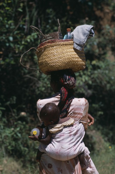 MADAGASCAR, People, Women, Near Ambositra. Portrait of a woman carrying a baby in a sling on her
