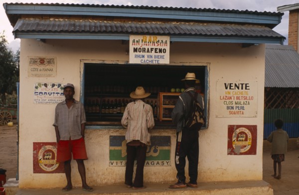 MADAGASCAR, Ihosy, Men standing at a kiosk which sells rum and beer