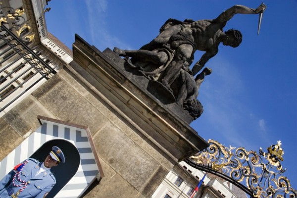 CZECH REPUBLIC, Bohemia, Prague, Soldier standing guard at a sentry box below an 18th Century