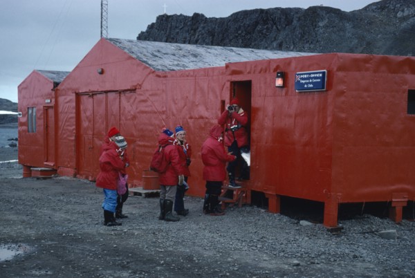 ANTARCTICA, King George Island, Teniente Marsh Station. Tourists wearing red jackets outside Post