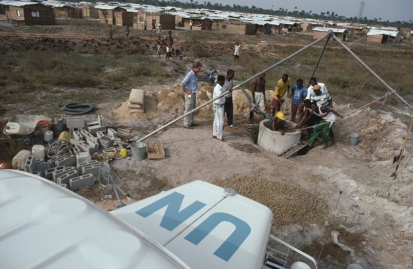 LIBERIA, War, UN peacekeeping team installing water pump and well in refugee camp for people