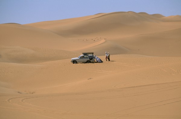 LIBYA, Sahara Desert, Tourists four by four vehicle stuck in Saharan sand.
