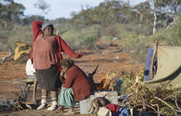 AUSTRALIA, Southern , Oak Valley, Aboriginal women in an Aborigine camp with one women stretching
