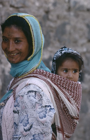 TURKEY, Diyarbakir, Portrait of Kurdish mother carrying child in sling on her back.