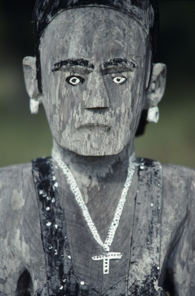 MADAGASCAR, Art, Mahafaly aloalo carved memorial post in form of human figure hung with cross