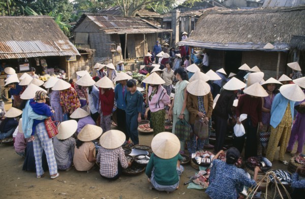 VIETNAM, Central, Hue, Village market near Mings Tomb with women wearing conical hats gathered