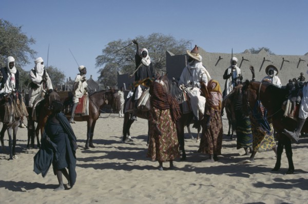 CHAD, People, Kanimbo men on horses holding swords above their heads as a welcoming to the Chiefs